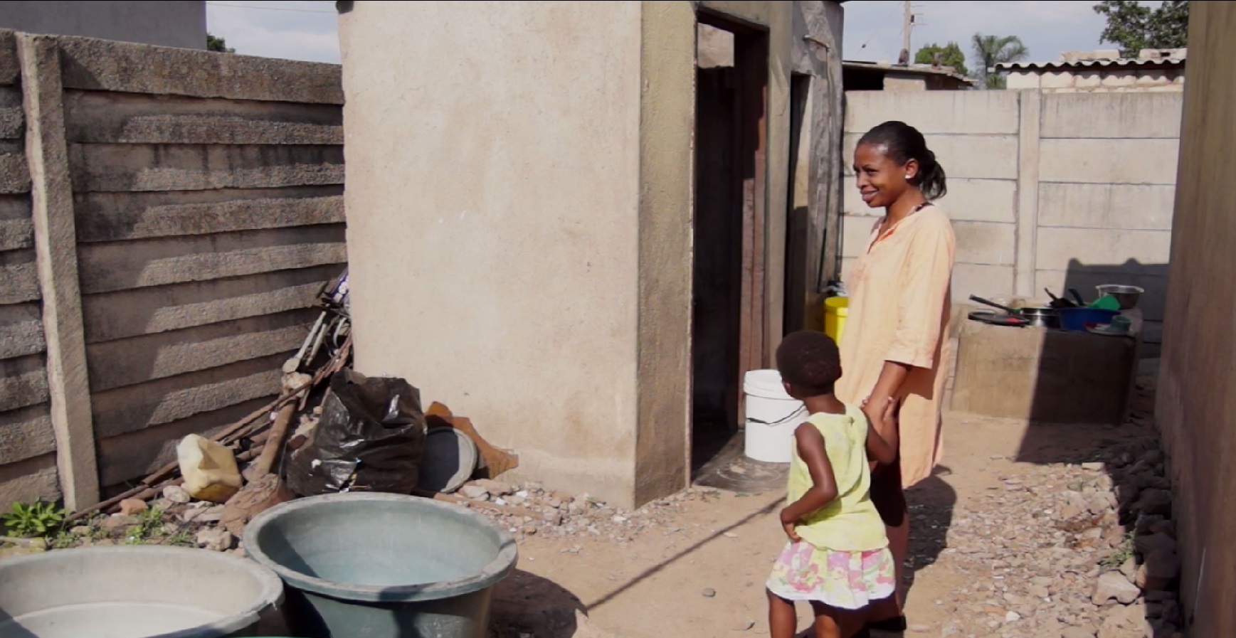 Mother and child from Zimbabwe village explaining their water supplies and use (see film). Photo.