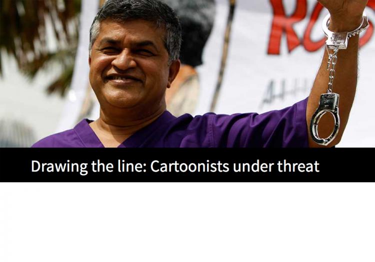 The Malaysian cartoonist Zunar raises a handcuffed arm at an event to promote his book in February 2015. Zunar is facing nine sedition charges. (AP/Joshua Paul)